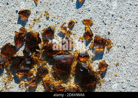 Top view of shattered glass on a textured white cement surface Stock Photo