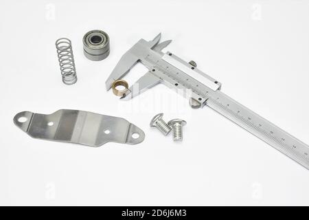 Measuring technical materials with vernier caliper.Vernier caliper,metal spring and bearing ball isolated white metal industry  background composition Stock Photo
