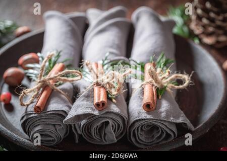 Closeup of Christmas table setting with napkin and gingerbread cookies on wooden table Stock Photo