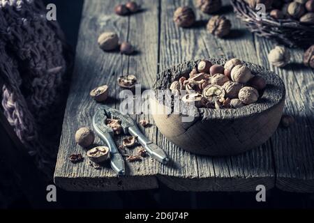 Closeup of various nuts and nutcracker on rustic wooden table Stock Photo