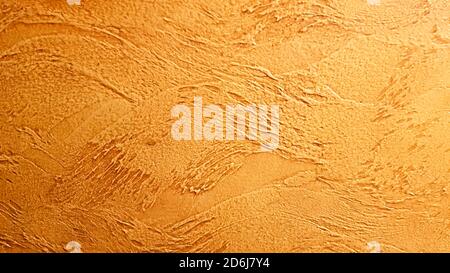 Texture of yellow decorative plaster. Abstract golden background for design with copy space for text. The surface of a beautiful cement or concrete wa Stock Photo