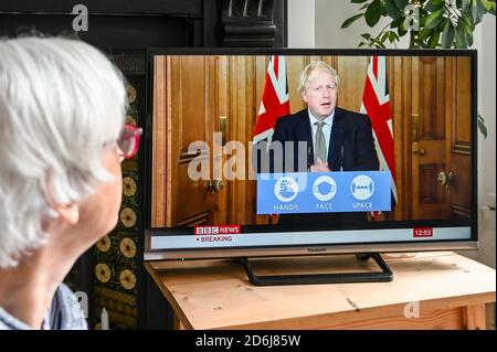 Prime Minister Boris Johnson giving a televised press conference from Downing Street in regard to Covid-19 with 'Hands, face space' logo advice.