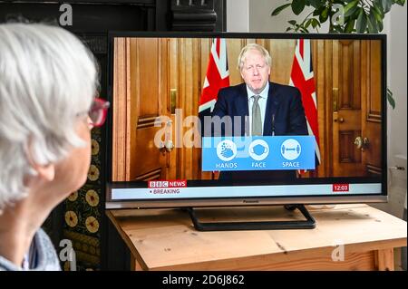 Prime Minister Boris Johnson giving a televised press conference from Downing Street in regard to Covid-19 with 'Hands, face space' logo advice.