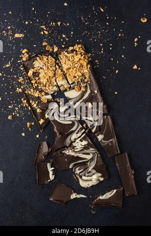 Dark chocolate bark isolated on a dark background. Top view, flat lay. Stock Photo