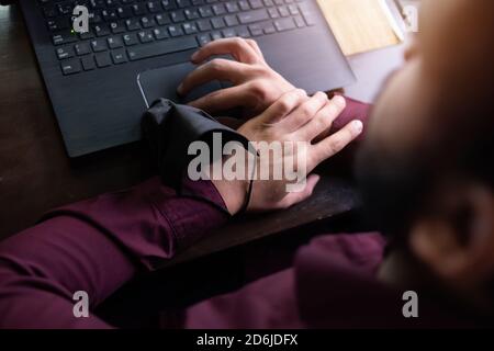 African businessman or developer wearing surgical face mask in the restaurant and typing on laptop - concept on new normal everyday lifestyle and peop Stock Photo