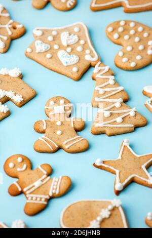 Happy New Year's set of gingerbread cookies and man in face mask from ginger biscuits glazed sugar icing decoration on blue background, minimal season Stock Photo