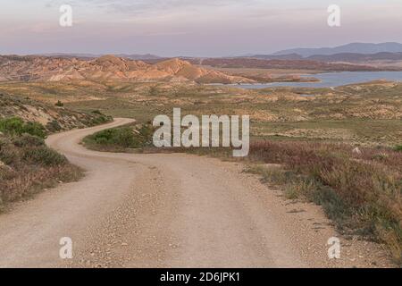 A winding dirt road leads through sagebrush grassland to the shore of Flaming Gorge Reservoir. Stock Photo