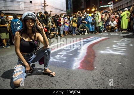 Bangkok, Thailand. 17th Oct, 2020. A pro-democracy protester seen posing next to a graffiti saying 'Republic of Thailand' during an anti-government demonstration in the Thai Capital. Thousands of pro-democracy protesters took the streets at Lat Phrao Intersection demanding the resignation of Thailand Prime Minister and the reform of the monarchy for the third day after a ‘severe state of emergency' declared by Prime Minister Prayut Chan-o-cha. Credit: SOPA Images Limited/Alamy Live News Stock Photo