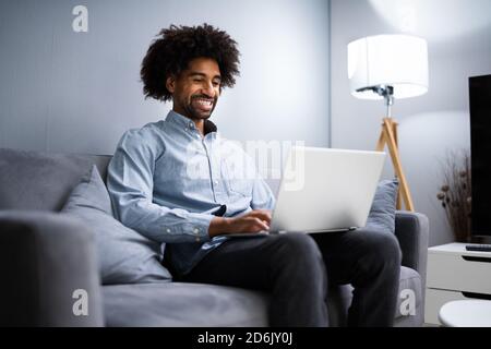 African American Man Using Laptop Computer Online Stock Photo