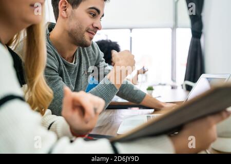 Two creative designers working in a project together, reading something on digital tablet and sharing new ideas on workplace. Business and team work c Stock Photo