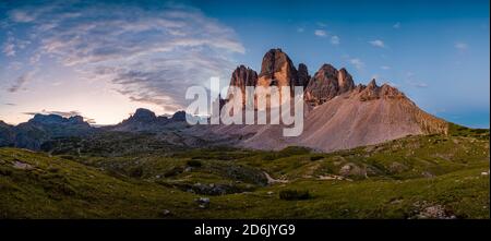 Panoramic view on the north faces of the mountain group Tre Cime di Lavaredo at sunrise. Stock Photo