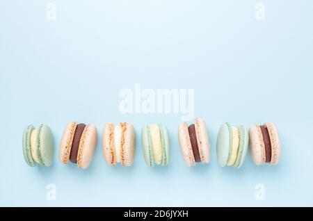 Creative flat lay. Various macarons on blue background. Copy space for your text - Image Stock Photo