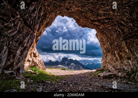 The mountain group Cadini di Misurina seen out of a cave above the mountain hut Auronzo, Rifugio Auronzo, dark thunderstorm clouds moving in. Stock Photo