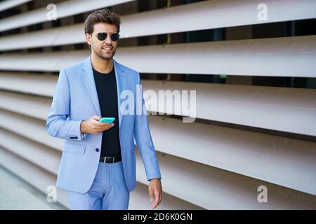 Man walking down the street using his smartphone Stock Photo