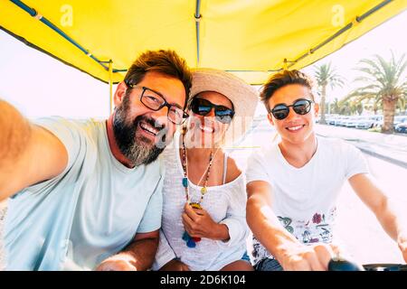 Happy caucasian family enjoy bike leisure activity outdoor together having lot of fun and laughing - holiday vacation for group of three people father Stock Photo