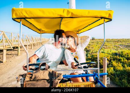 Happy adult couple enjoy and love together in bike outdoor leisure activity during travel vacation - summer people enjoying holidays and having fun to