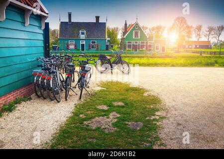 Great touristic location with traditional wooden houses at dawn. Bicycles parked near wooden house at sunrise, Zaanse Schans, Netherlands, Europe Stock Photo