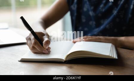 Crop of woman writing in notebook making plans Stock Photo