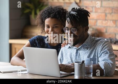Happy African American couple work on laptop at home Stock Photo