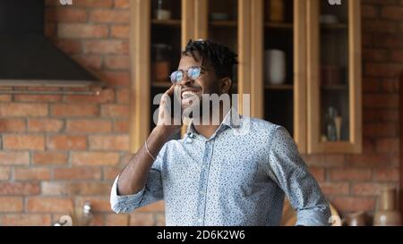 Smiling young biracial man laugh talking on cellphone Stock Photo