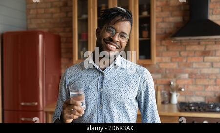 Portrait of smiling biracial man with clean mineral water Stock Photo