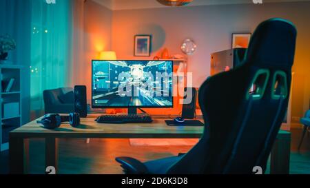 Powerful Personal Computer Gamer Rig with First-Person Shooter Game on Screen. Monitor Stands on the Table at Home. Cozy Room with Modern Design is Stock Photo