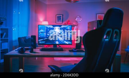 Powerful Personal Computer Gamer Rig with First-Person Shooter Game on Screen. Monitor Stands on the Table at Home. Cozy Room with Modern Design is Stock Photo