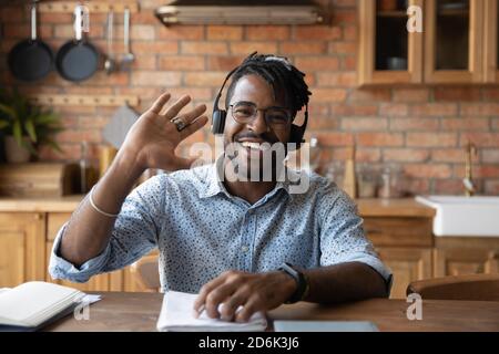 Portrait of smiling biracial man wave talk on video call Stock Photo