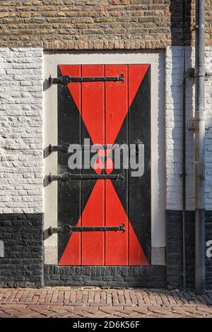 Old wooden medieval door with beautiful ornaments in a stone wall Stock Photo