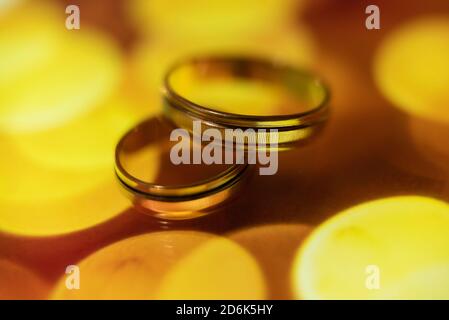 wedding rings in warm colors with reflection Stock Photo