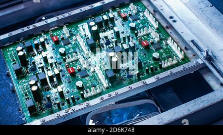 Electronic Printed Circuit Board with Microchips, Transistors, Semiconductors, Capacitors Water Cooling Process on the Assembly Line During Stock Photo