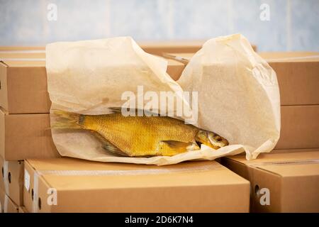 Smoked mackerel lies on cardboard boxes in a warehouse. Stock Photo
