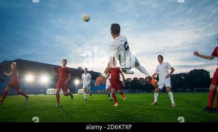 Soccer Player Receives Successful Pass and Kicks Ball to Score Amazing Goal doing Bicycle Kick. Shot Made on a Stadium Championship. Stock Photo