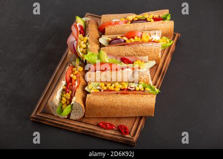 Delicious sandwiches with ham vegetables and sauce close up on a dark table, close up Stock Photo
