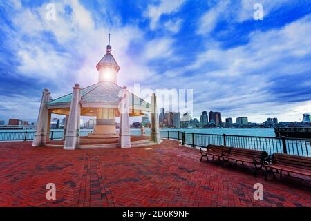 East Boston Piers Park Gazebo with lighthouse light in the evening over downtown panorama view Stock Photo