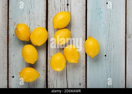 Fresh fragrant lemons on a blue wooden table, top view Stock Photo