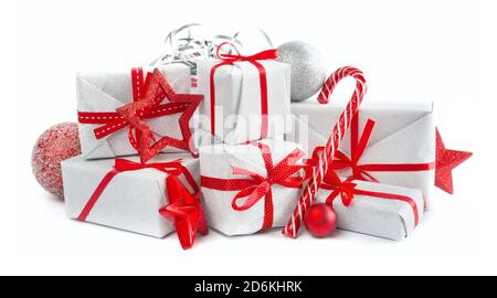 Heap of similar Christmas silver gift boxes with red ribbon decor stars baubles and candy cane isolated on white background Stock Photo