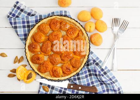 Homemade apricot pie with fresh fruits on white wooden table. Top view. Stock Photo