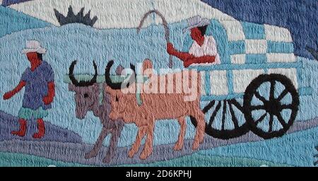 Sisal harvest being taken to market in a zebu wagon as shown in carefully stitched tapestry. Stock Photo