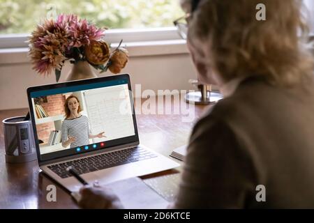 Rear view close up mature woman watching webinar, learning language Stock Photo