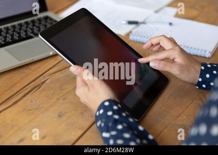 Closeup female hands holding tablet with white mockup empty screen Stock Photo
