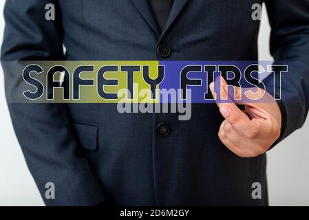 Writing note showing Safety First. Business concept for Avoid any unnecessary risk Live Safely Be Careful Pay attention Model with pointing hand finge Stock Photo