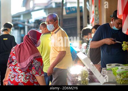 Kuala Lumpur, Malaysia. 18th Oct, 2020. Residents wearing masks shop in a market in Kuala Lumpur, Malaysia, Oct. 18, 2020. Malaysia recorded daily high of new COVID-19 infections for a second consecutive day with 871 reported Sunday, bringing the national total to 20,498, the Health Ministry said. Credit: Chong Voon Chung/Xinhua/Alamy Live News Stock Photo