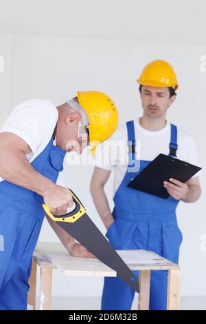 Business, building, teamwork and people concept - group of builders in hardhats with tools indoors Stock Photo