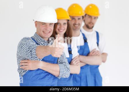 Team of happy workers in uniform ready to work, man showing thumb up sign Stock Photo
