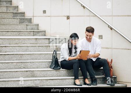 Business people sitting on steps Stock Photo