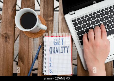 Conceptual hand writing showing Get Quality. Concept meaning features and characteristics of product that satisfy needs Workplace overview with laptop Stock Photo
