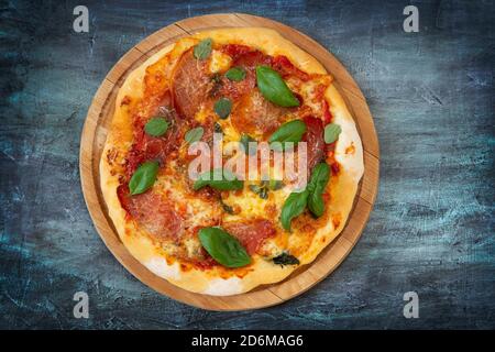 Pizza on wooden board from above Stock Photo