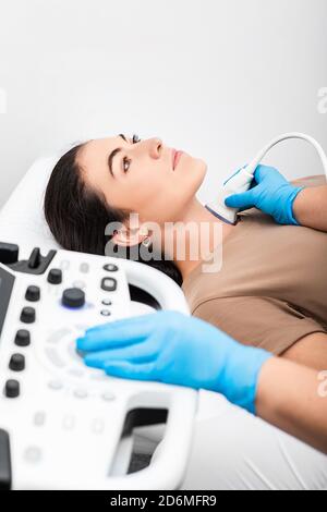 Ultrasound diagnostics of the endocrine system and thyroid for woman. A female patient receives thyroid diagnostics. Treatment of thyrotoxicosis, and Stock Photo