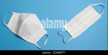 Two white reusable medical masks on dark blue background isolated Hygienic surgical, antiviral mask Concept of protective equipment against coronaviru Stock Photo